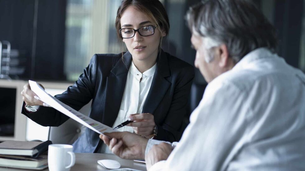 man and woman looking at documents together in office