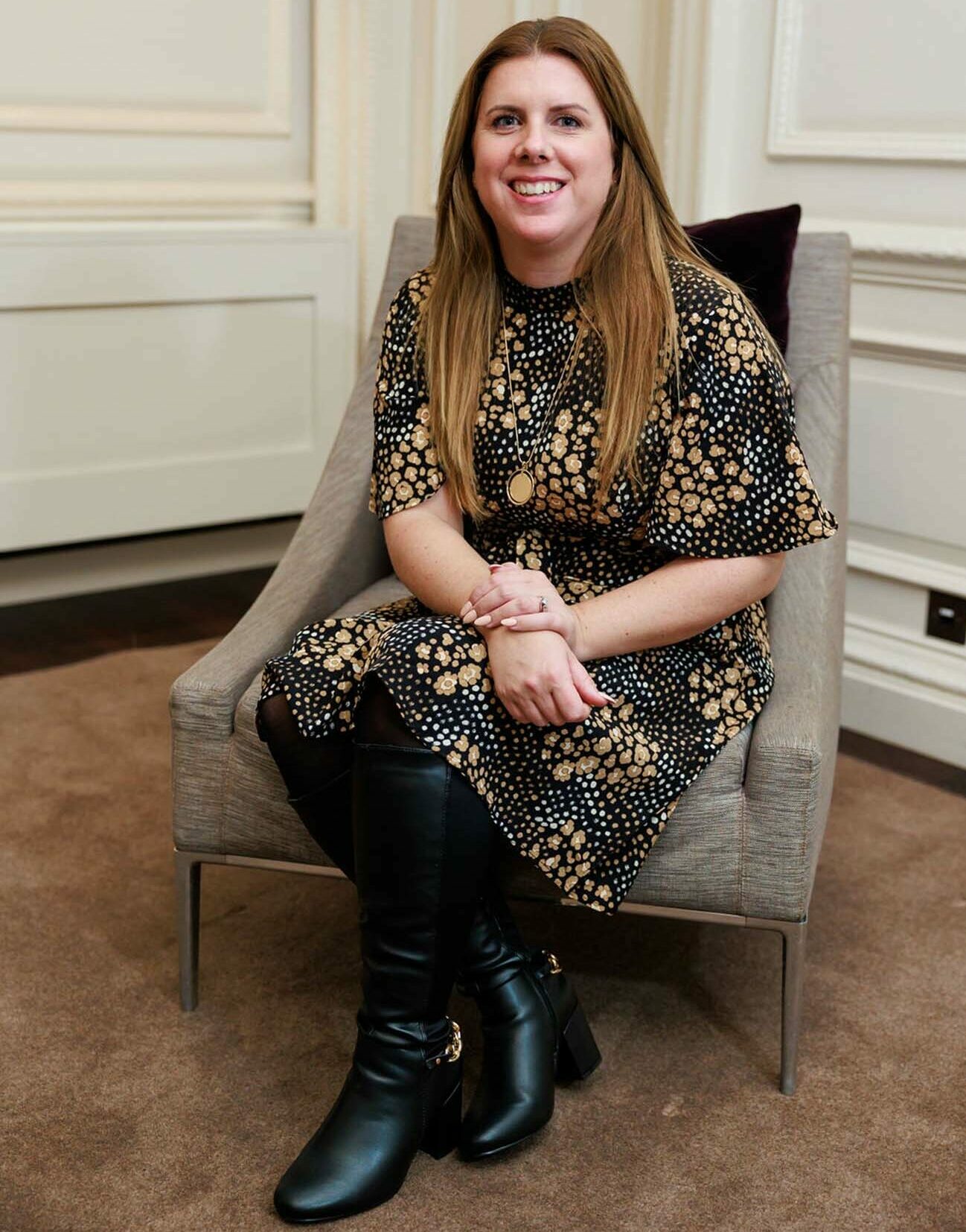 Laura sat at chair smiling at camera
