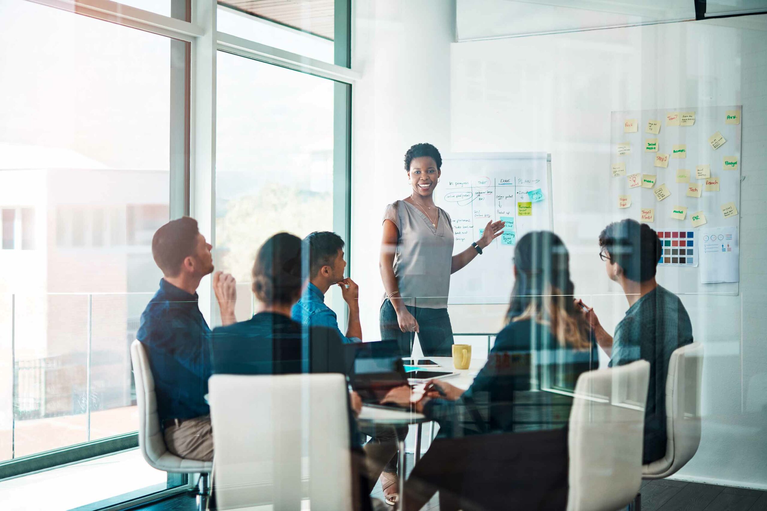 Woman giving presentation to a boardroom of people