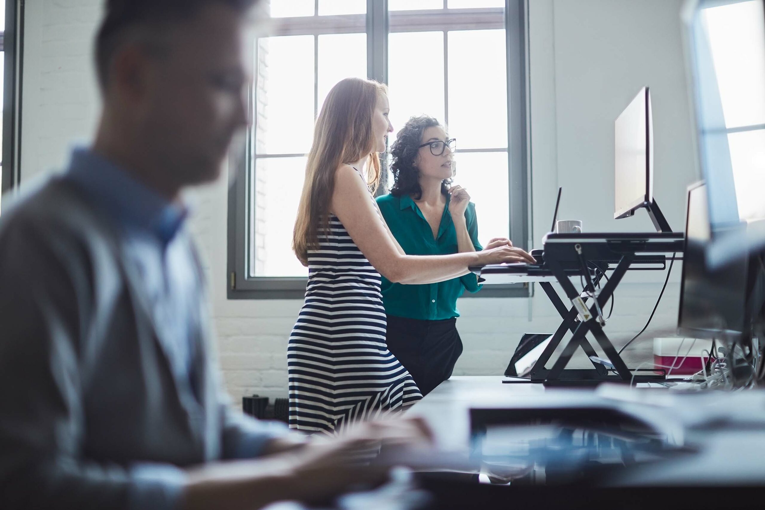 two women working at stand up desk