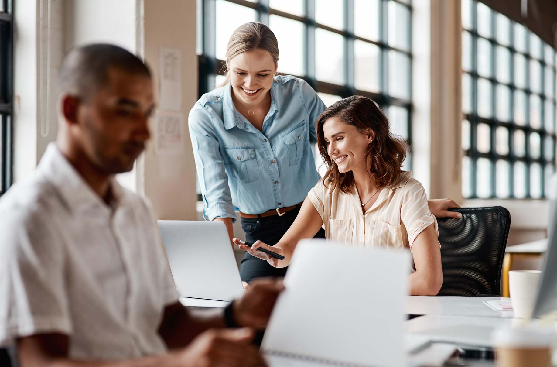 women collaborating with a laptop in office