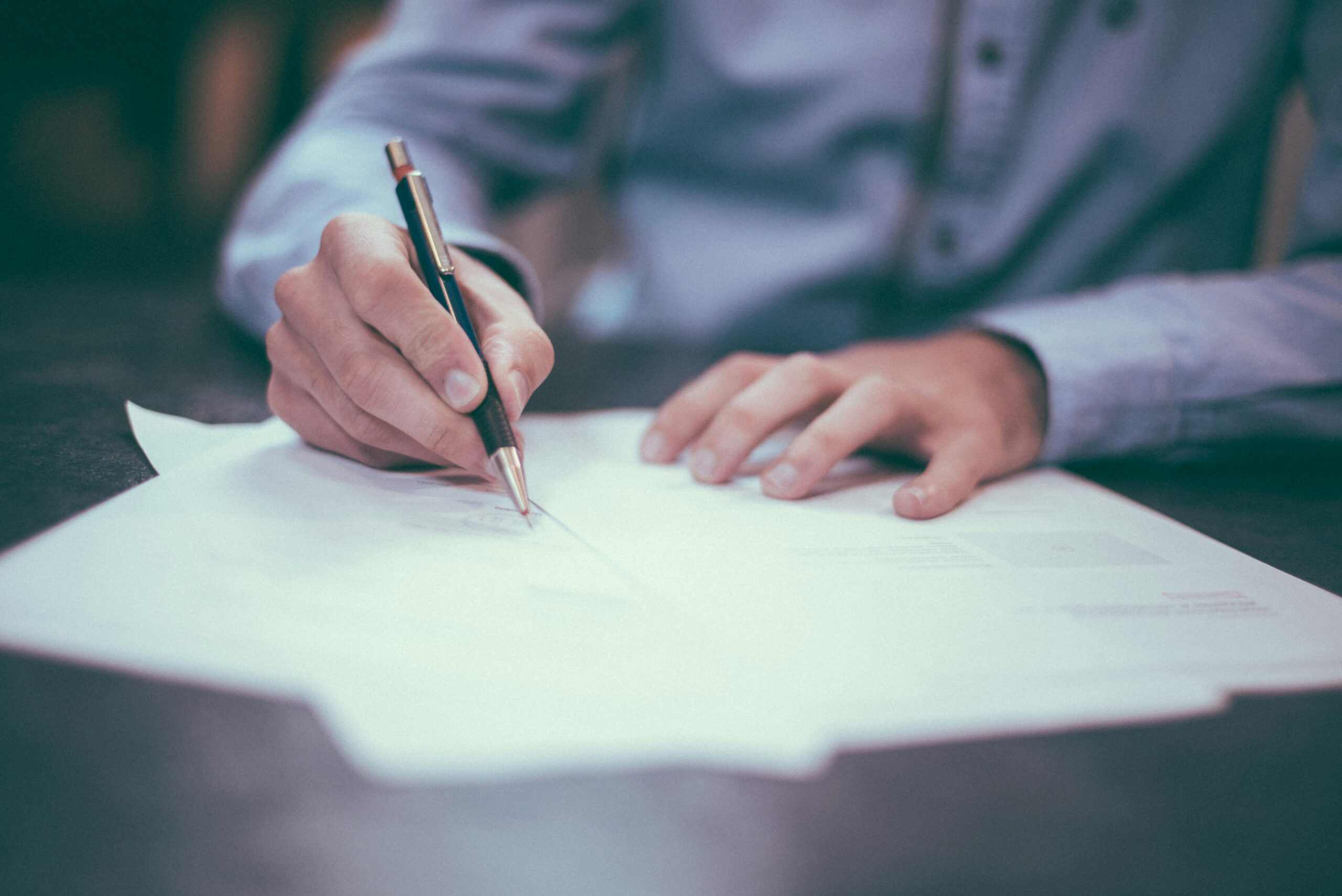 close up of man signing papers